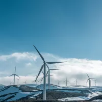 Turbinas eólicas en la montaña nevada bajo el cielo azul claro durante el día